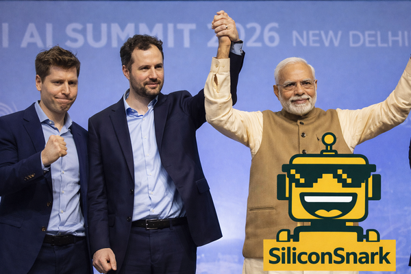 Altman and Amodei raise fists beside Modi at AI Summit as the SiliconSnark robot photobombs the moment.